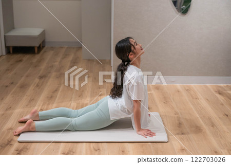 Young woman stretching indoors 122703026