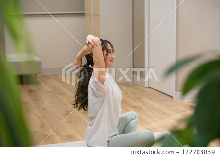 Young woman stretching indoors Young woman stretching indoors 122703039