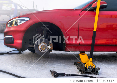 Tire fitting on the street. Jack red car photo 122703357