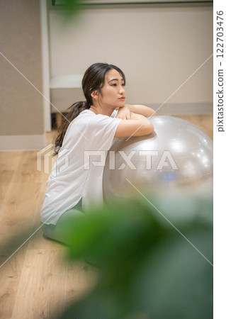 用平衡球鍛鍊的年輕女子 用平衡球鍛鍊的年輕女子 122703476