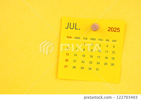 July 2025 calendar sheet with thumbtack on yellow background. 122703483