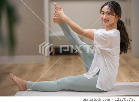 Young woman stretching her legs 122703755