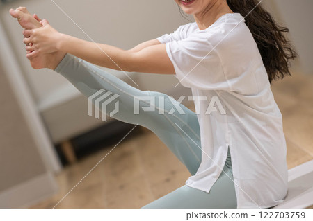 Young woman stretching her legs 122703759
