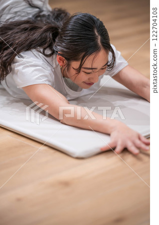 Smiling young woman stretching Smiling young woman stretching 122704108