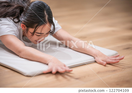 Smiling young woman stretching Smiling young woman stretching 122704109