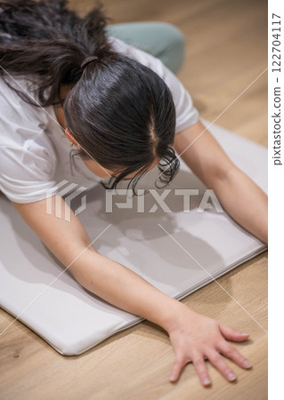 Smiling young woman stretching 122704117