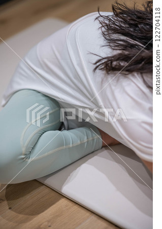 Smiling young woman stretching Smiling young woman stretching 122704118