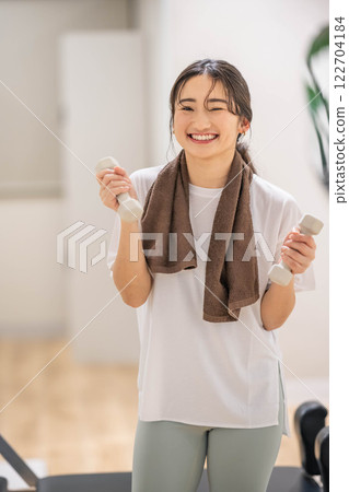 年輕女子用啞鈴訓練 年輕女子用啞鈴訓練 122704184