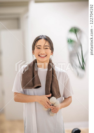 Young woman training with dumbbells 122704192