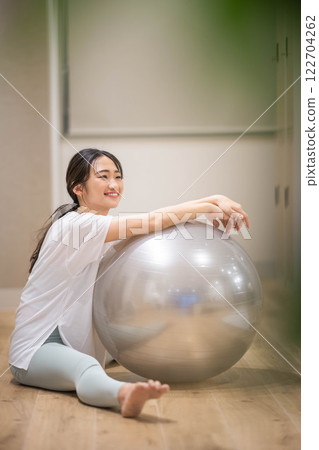 Young woman exercising with balance ball in indoor gym 122704262