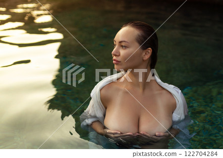 Nude sexy woman in water at sunset. Beautiful blonde woman with short wet hair and big breasts, art portrait in sea Nude sexy woman in water at sunset. Beautiful blonde woman with short wet hair and big breasts, art portrait in sea 122704284