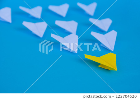 Close up view of yellow paper airplane origami leading white airplanes with customizable space for text. Business and Leadership skills concept 122704520