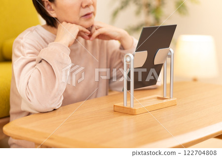 A middle-aged woman in pajamas worrying about skin care in her room on a winter night 122704808