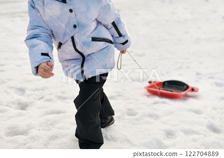 A child with snow bob sledding in the snow A child with snow bob sledding in the snow 122704889