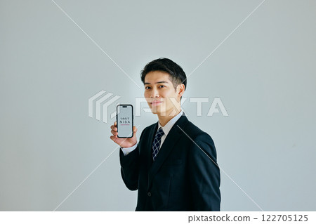 A young man in his twenties holding a smartphone 122705125