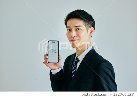 A young man in his twenties holding a smartphone 122705127
