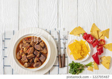 beef stew in a white bowl on rustic wooden table 122705487