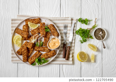 pretzel crusted fish sticks with lemon, mayo sauce 122705490