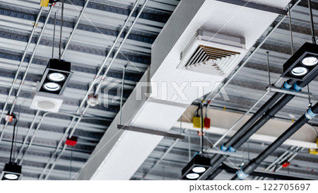 Electrical cable conduits wiring with junction boxes, part of plumbing pipeline and ceiling air vent 122705697