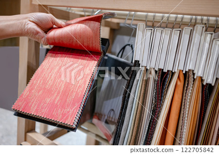 Designer hand choosing fabric pieces from fabric swatch material 122705842