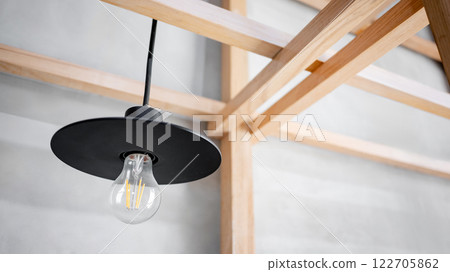 Industrial loft pendant lamp hanging on wooden structure in office building 122705862
