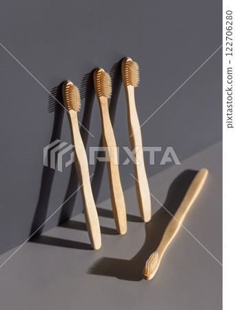 Biodegradable bamboo toothbrushes on a grey two tones background with hard shadow closeup, mockup 122706280