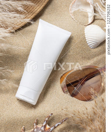 White cream tube, sunglasses, pampas grass and seashells on a sand, Sunscreen cosmetic mockup 122706282