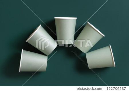 Disposable light green paper cups on a dark green top view, mockup. Sustainable lifestyle Disposable light green paper cups on a dark green top view, mockup. Sustainable lifestyle 122706287