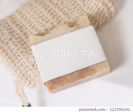 Beige handmade soap bar with blank label on soap saver bag on washbasin close up, mockup Beige handmade soap bar with blank label on soap saver bag on washbasin close up, mockup 122706292