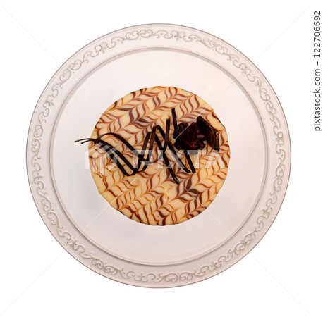 Cake with vanilla and chocolate decoration on a plate - top view 122706692