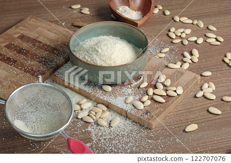 Almond flour in bowl. Nuts on table. Healthy food and products. Organic ingredients and vegan nutrition. Almond flour in bowl. Nuts on table. Healthy food and products. Organic ingredients and vegan nutrition. 122707076