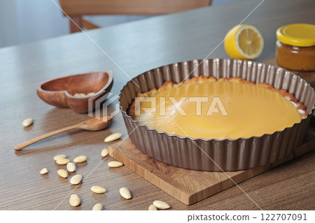 Cake made of almond flour and natural fruit in mold for baking in kitchen. Nuts on table. Healthy food and products. Organic ingredients and vegan nutrition.  122707091