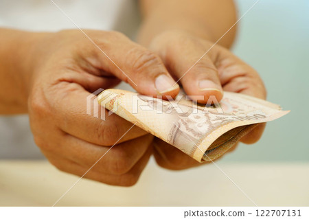 Asian woman counting Thai baht banknote money and holding in hand, investment economy, accounting business and banking. 122707131