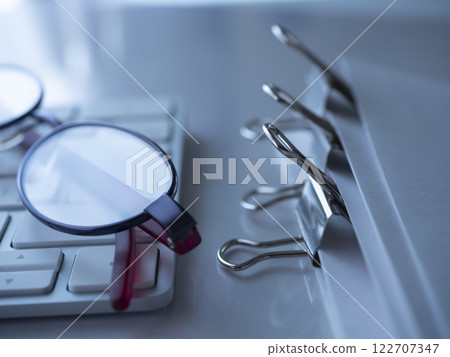 桌上的文件、鍵盤和眼鏡 桌上的文件、鍵盤和眼鏡 122707347