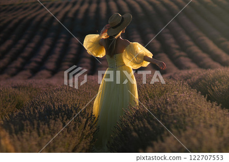 Woman Lavender Field Provence: Golden hour portrait of woman in yellow dress enjoying lavender field in Provence, France, summer. Woman Lavender Field Provence: Golden hour portrait of woman in yellow dress enjoying lavender field in Provence, France, summer. 122707553
