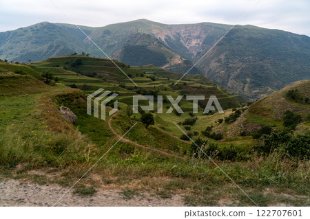 Chokhsky terraces Dagestan. Landscape of mountainous Dagestan with terraced fields and peaks mountains in the distance. 122707601