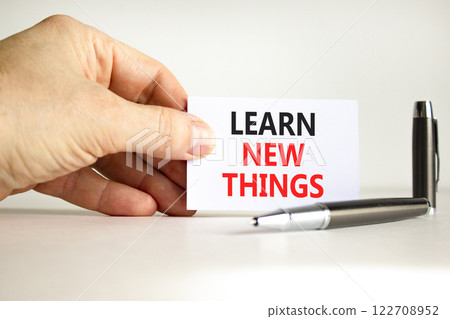 Learn new things symbol. Concept words Learn new things on beautiful white card. Beautiful white background. Businessman hand. Business motivational learn new things concept. Copy space. 122708952
