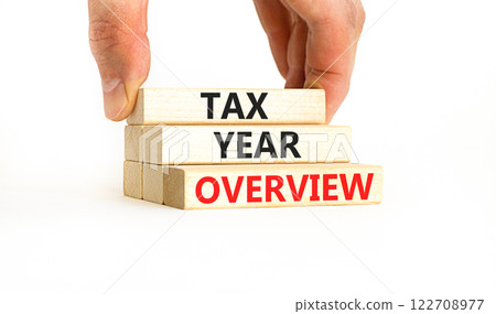 Tax year overview symbol. Concept words Tax year overview on beautiful wooden blocks. Beautiful white table white background. Businessman hand. Business tax year overview concept. Copy space. 122708977