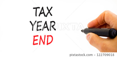 Tax year end symbol. Concept words Tax year end on beautiful white paper. Beautiful white background. Businessman hand. Business tax year end concept. Copy space. Tax year end symbol. Concept words Tax year end on beautiful white paper. Beautiful white background. Businessman hand. Business tax year end concept. Copy space. 122709018
