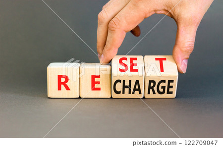 Reset and recharge symbol. Concept words Reset Recharge on beautiful wooden block. Beautiful grey table grey background. Businessman hand. Business reset and recharge concept. Copy space. 122709047