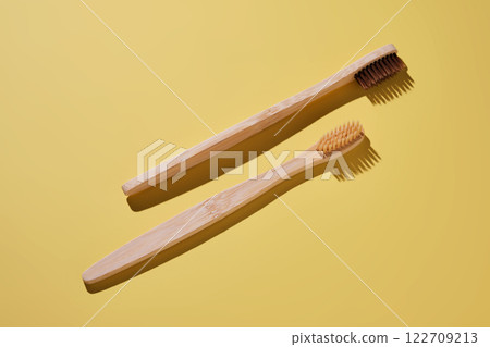 Two toothbrushes on a yellow background. 122709213