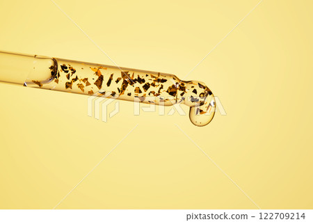 24 k gold facial serum in a pipette on a yellow background. 24 k gold facial serum in a pipette on a yellow background. 122709214