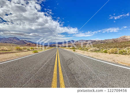 A long desert road disappearing into the distant mountains of Arizona 122709456