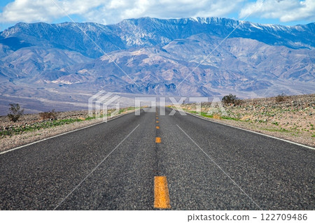 A long desert road disappearing into the distant mountains of Arizona A long desert road disappearing into the distant mountains of Arizona 122709486