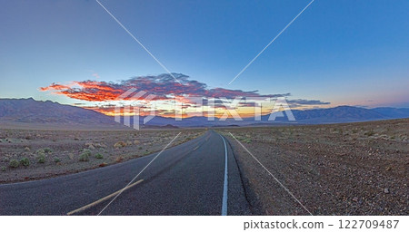 Scenic desert road at sunset with colorful clouds and mountain backdrop Scenic desert road at sunset with colorful clouds and mountain backdrop 122709487