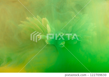 beautiful flower with white petals in clouds of green and yellow smoke on black background, photo underwater, clouds of paint in water, aquarium, spring concept, creativity, art 122709630