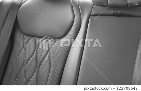 Back passenger black seats in modern luxury car. Black perforated leather with white stitching. Car details. Leather comfortable seats. Car interior details Back passenger black seats in modern luxury car. Black perforated leather with white stitching. Car details. Leather comfortable seats. Car interior details 122709642
