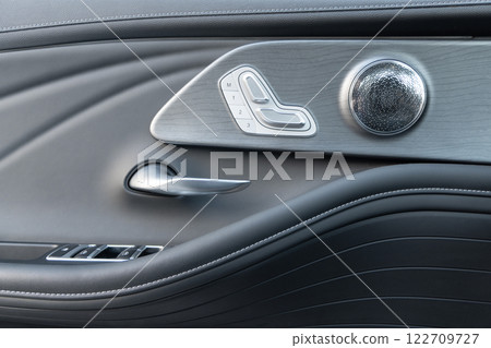 Door handle with Power seat control buttons of a luxury passenger car. Black leather interior of the luxury modern car. Modern car interior details Door handle with Power seat control buttons of a luxury passenger car. Black leather interior of the luxury modern car. Modern car interior details 122709727