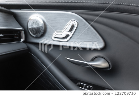 Door handle with Power seat control buttons of a luxury passenger car. Black leather interior of the luxury modern car. Modern car interior details 122709730