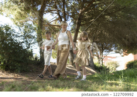 Family strolling in sunlit forest path 122709992